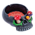 Angled view of the Black Skull Pink Brain & Mushroom Eyes Ashtray with black skull and red brain bowl.