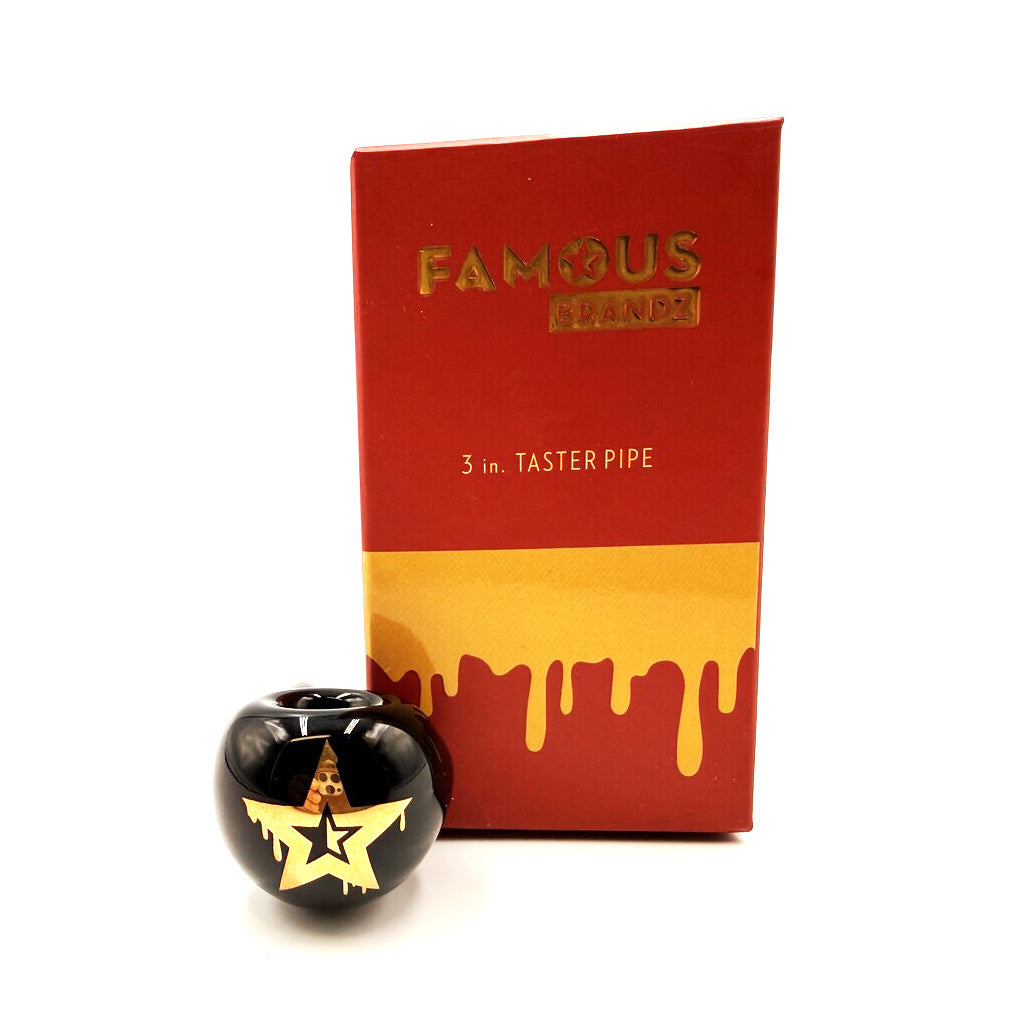 Close up of black glass Taster Pipe Surrender one hitter with gold star graphic