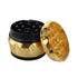 Vintage aluminum herb grinder opened to show sharp diamond teeth and a matching gold lid